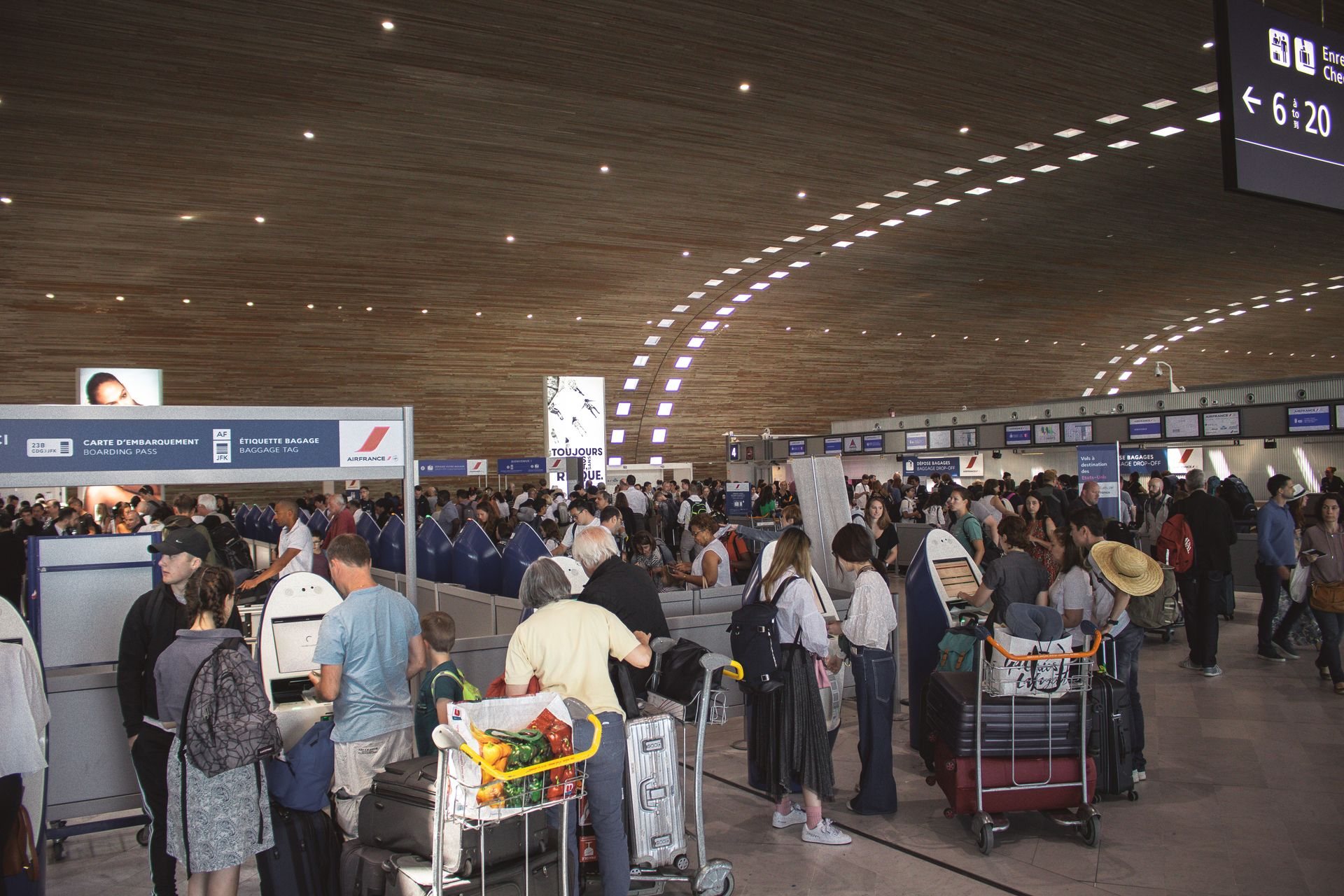 Passengers queuing at airport check-in counters and kiosks