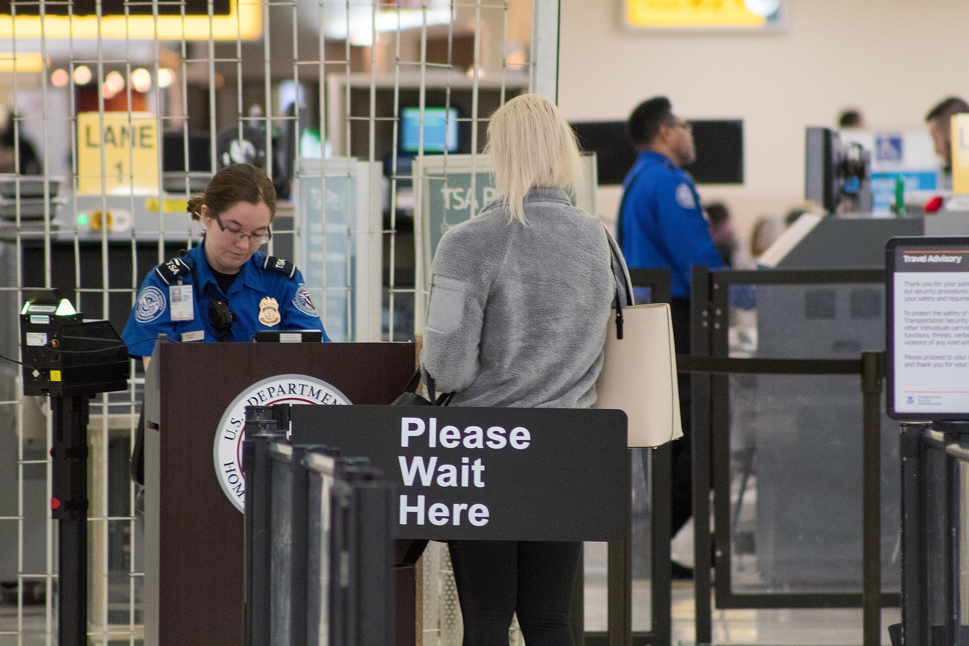 TSA officer checking a passenger's documents at a security checkpoint